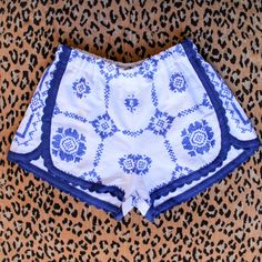 a pair of blue and white shorts sitting on top of a leopard print surface