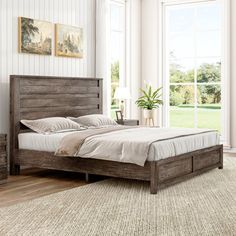 a large bed sitting in a bedroom on top of a wooden floor next to a window