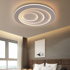 a bed room with a neatly made bed and a round light above the headboard