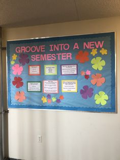 a bulletin board with flowers on it in an office cubicle area that reads grovee into a new semester