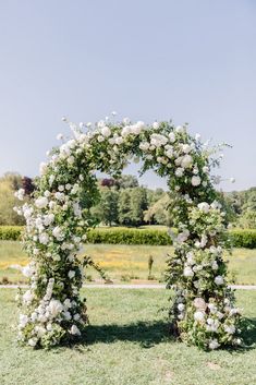 an outdoor ceremony with white flowers and greenery