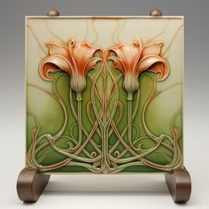 an art deco tile with two flowers on it's front and back sides, sitting on wooden wheels