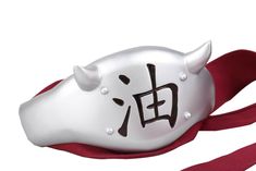 a white cow mask with chinese writing on it's face and red ribbon around its neck