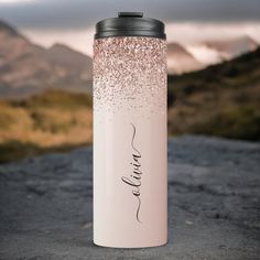 a pink and white water bottle with the word love written on it in black ink