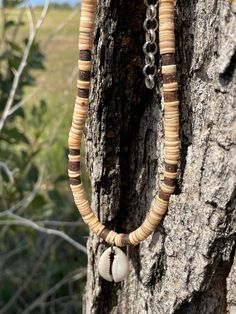 "Choker is made from thinly sliced shell heishi beads and coconut heishi beads. It has a cowrie shell for a pendant. Length is 16\" and has a chain adjustment. Item 329" Brown Shell-shaped Jewelry For Vacation, Brown Shell Jewelry For Vacation, Handmade Brown Shell Necklace For Vacation, Brown Shell Necklace For Vacation, Handmade Bohemian Heishi Beads Shell Necklace, Bohemian Handmade Shell Necklace With Heishi Beads, Handmade Bohemian Shell Necklace With Heishi Beads, Beaded Brown Shell Necklace For Beach, Brown Beaded Shell Necklace For The Beach