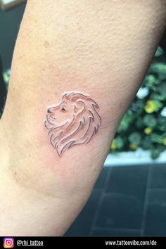 a small lion tattoo on the arm