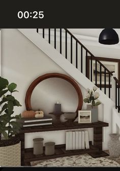 a living room filled with furniture next to a stair case and potted plant on top of a wooden table