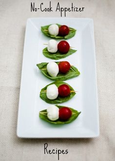 small appetizers are arranged on green leafy leaves