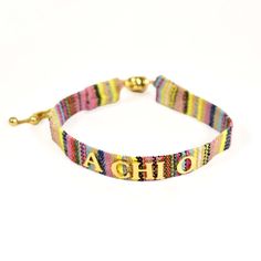 a colorful bracelet with the word ahoh written in gold letters on an adjustable clasp