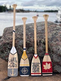 four paddles are lined up next to a rock