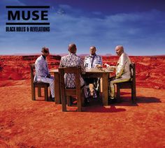 three men sitting at a table in the middle of a red desert with blue sky