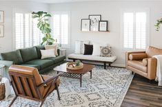 a living room with couches, chairs and rugs on the hardwood flooring