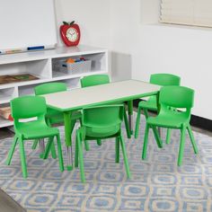 a white table and green chairs in a room with bookshelves on the wall