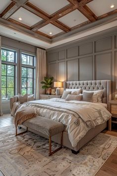 a large bed sitting in the middle of a bedroom next to two lamps and windows