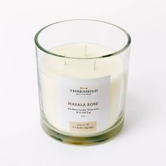 a candle that is sitting in a glass container on a white surface with the words, fire