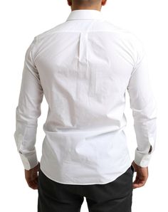 Step into the world of high fashion with this stunning white dress shirt from Dolce & Gabbana. Tailored to a slim fit, this piece is perfect for any sophisticated wardrobe, offering unmatched style and comfort for those who appreciate luxury. This shirt, coming from the MARTINI line, features a classical neck, long sleeves, and exhibits the brand’s keen eye for detail. Made in Italy, this garment is a testament to the brand’s commitment to premium quality. Material: 100% Cotton Color: White Coun White Martini, Sophisticated Wardrobe, Tory Burch Ella, White Dress Shirt, Embroidery Shoes, Dolce E Gabbana, Dolce And Gabbana Man, White Shirt Dress, Formal Shirts