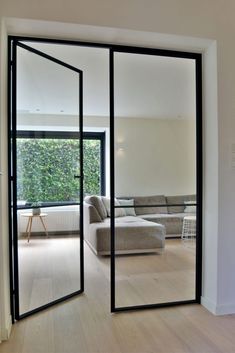 an open door leading to a living room with a couch and table in front of it