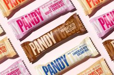 many different types of candy bars are arranged in a row on a pink background with white lettering