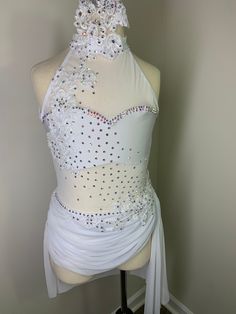 a mannequin wearing a white dress with lots of beads on it's neck