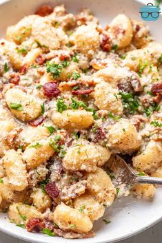 a white bowl filled with pasta and meat covered in parmesan cheese on top