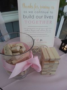 a glass bowl filled with wine corks next to a sign that says, thanks for joining us as we continue to build our lives together