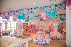 a room filled with tables and chairs covered in balloons