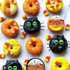 there are many donuts decorated to look like cats and candy corn on the top