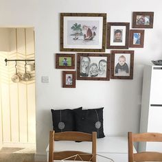 a dining room table with chairs and pictures on the wall above it, in front of a white refrigerator