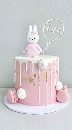 a pink cake with white frosting and an adorable bunny on top that says love