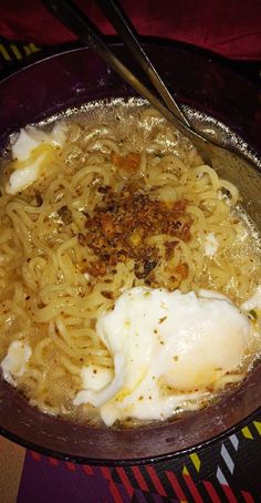 a bowl filled with noodles and eggs on top of a table