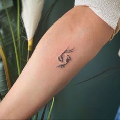 a woman's arm with a small wave tattoo on it