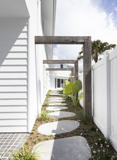 the walkway is lined with stepping stones leading to an open air space between two buildings