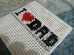 a white plate with black and red beads on it that says i love my dad