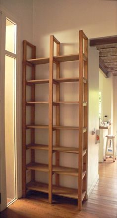 an empty room with wooden shelves and hard wood flooring