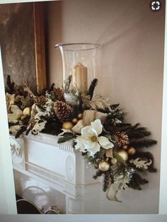 a christmas mantle decorated with pine cones and flowers