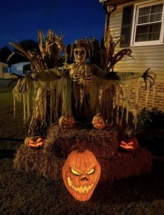 an outdoor halloween scene with pumpkins and scarecrows