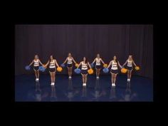 a group of cheerleaders standing on top of a blue floor holding pom poms