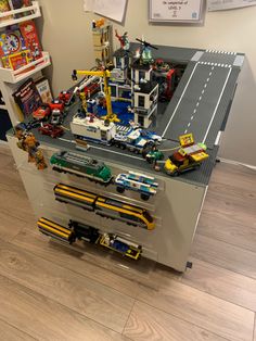 a lego train station with cars and trucks on the tracks