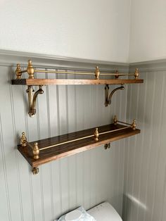 two wooden shelves above a toilet in a bathroom