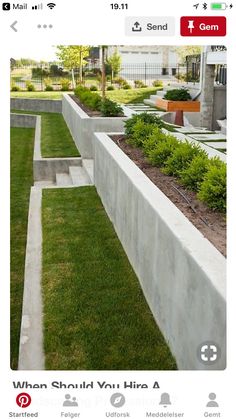 an outdoor garden with grass and plants in the center, surrounded by concrete blocks on either side