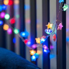 a string of colorful lights hanging from the side of a bed