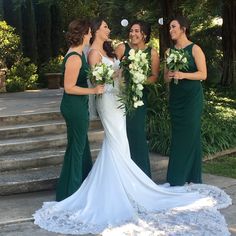 three bridesmaids in green dresses stand on the steps and talk to each other