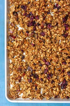 granola in a white baking dish on a blue surface