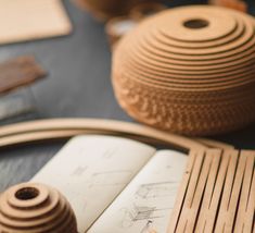 an open book sitting on top of a table next to a vase and other items