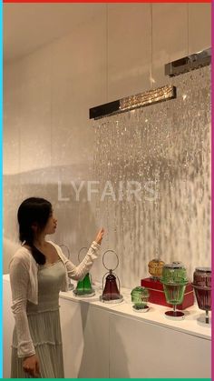 a woman is looking at some glass items