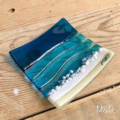 a blue and white glass dish sitting on top of a wooden table next to a wood floor