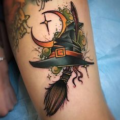 a woman's leg with a witch hat and broom on it