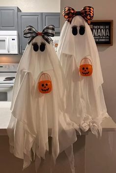 two halloween ghost glasses hanging on the kitchen counter