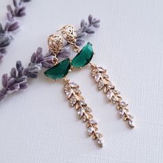 Gold Emerald Green Earrings for brides, weddings and bridal showers. The perfect gift earrings for bridesmaids, mother of the groom, or mother of the bride. Find earrings for bridal bachelorette party or other special occasions here. A gentle cascade of shimmering gold crystal leaves and Emerald Green crystals in these beautiful nature-inspired bridal earrings. Adding just a hint of sparkle, this pretty pair make gorgeous earrings for both brides and bridesmaids.  Emerald Green glass crystals ad Elegant Green Crystal Earrings For Weddings, Green Elegant Wedding Earrings, Green Drop Earrings For Bridesmaid Gift, Green Cluster Earrings For Wedding, Elegant Green Chandelier Earrings For Wedding, Green Dangle Clip-on Earrings For Wedding, Elegant Green Clip-on Earrings For Wedding, Elegant Green Bridal Earrings For Bridesmaids, Green Clip-on Earrings For Wedding