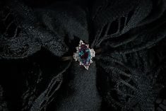 an image of a ring on top of a black piece of cloth that has been pinned to it